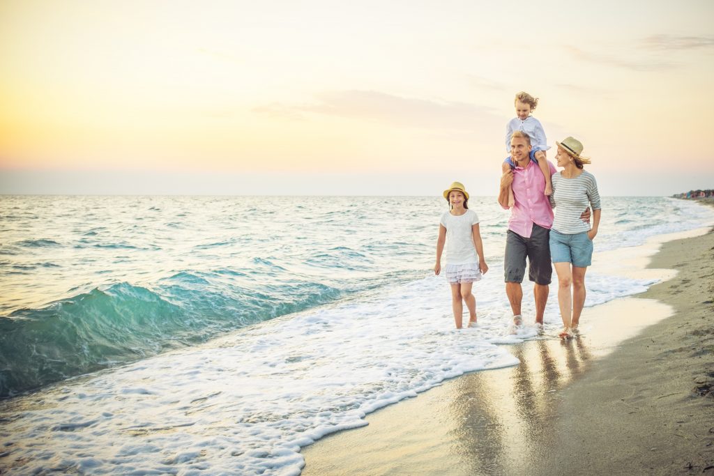 Happy family walking along a sandy beach